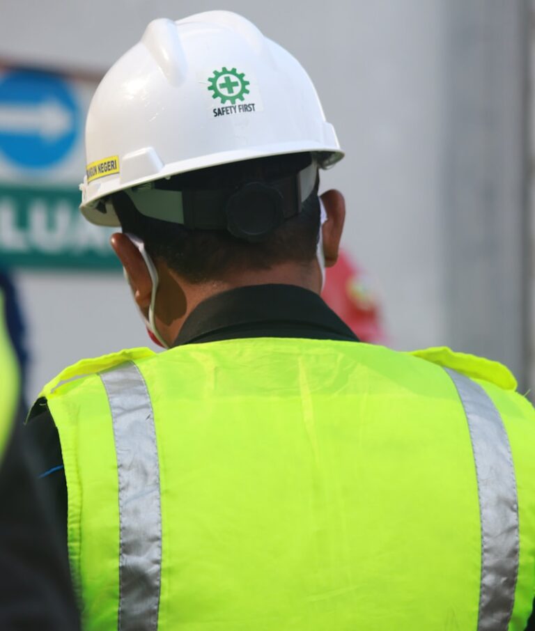 man in yellow and black vest wearing white helmet